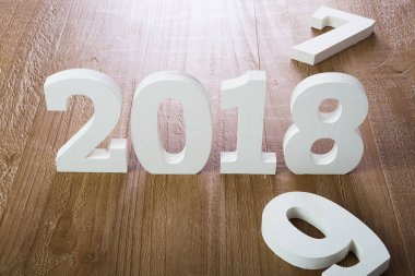 Ahşap arka plan üzerinde beyaz rakamlar 2018 