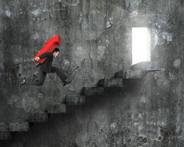 Empresário carregando sinal de seta vermelha correndo em escadas com porta — Fotografia de Stock