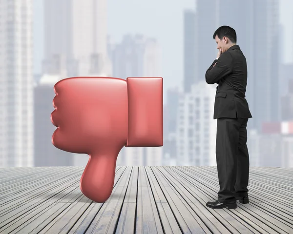 Standing man looking at dislike thumb down mark — Stock Photo, Image