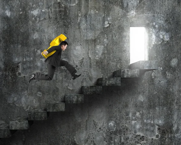 Homem carregando sinal de dólar dourado correndo em escadas de concreto velho — Fotografia de Stock