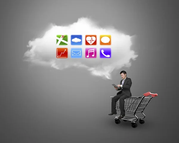 Alışveriş sepeti beyaz bulut ile oturan tablet kullanan adam — Stok fotoğraf