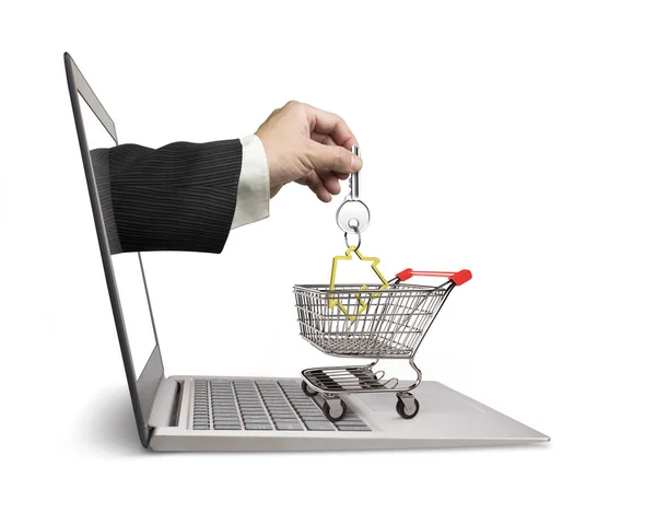 Hand from laptop screen taking house key in shopping cart — Stock Photo, Image