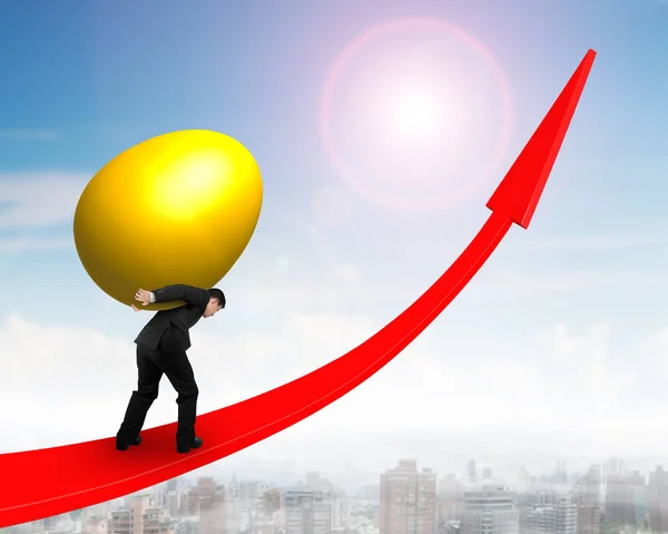 Man carrying golden egg upward on red trend line — Stock Photo, Image