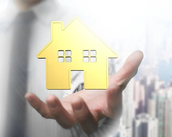 Man's hand showing golden house — Stock Photo, Image