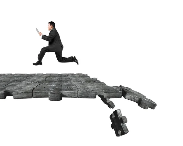 Man using tablet running on breaking puzzle ground — Stock Photo, Image