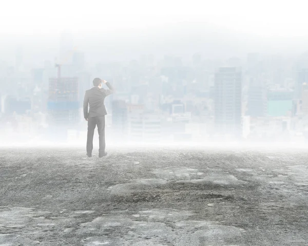 Homem de pé e olhando edifícios da cidade em névoa — Fotografia de Stock
