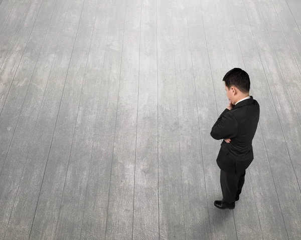 Uomo d'affari in piedi che tiene per mano il mento e pensa: — Foto Stock