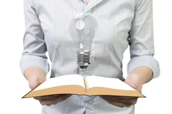 Hands holding open book with light bulb — Stock Photo, Image