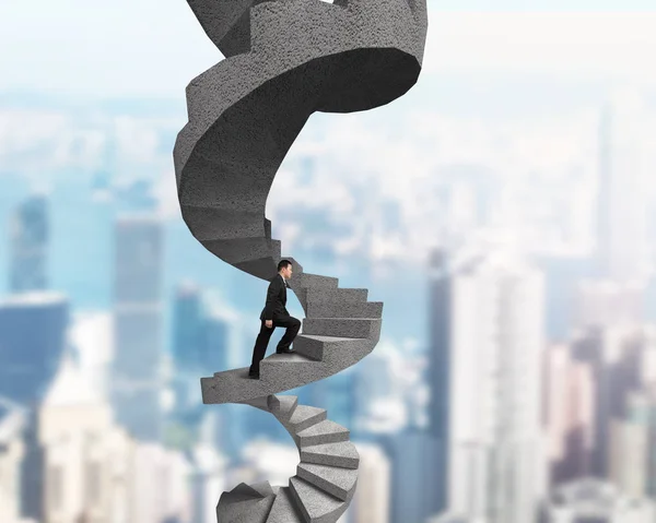 Businessman climbing concrete spiral staircase — Stock Photo, Image