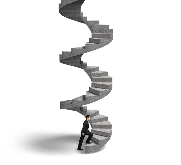 Businessman climbing concrete spiral staircase — Stock Photo, Image