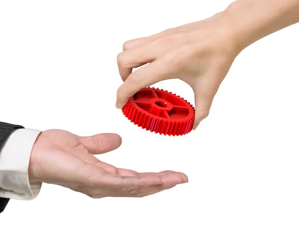 Ręka kobiety dając czerwone koła zębatego do ręki człowieka — Zdjęcie stockowe