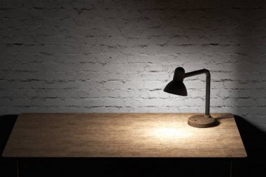 Ahşap masa masa lambası sarı ışık ile aydınlatılmış