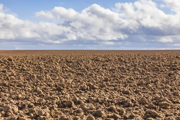 Empty filed against a cloudy sky