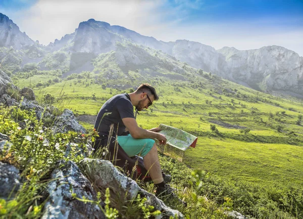 Der Wanderer mit einer Landkarte in nebligen Bergen — Stockfoto