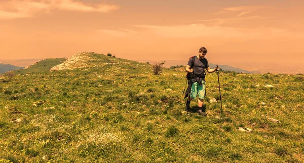 Uomo Escursioni nel verde delle montagne — Foto Stock