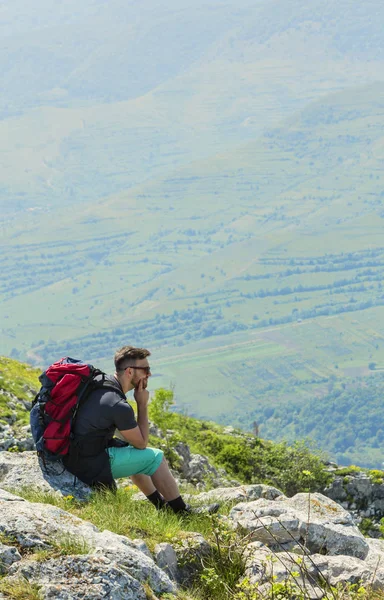 Escursionista che riposa sulle rocce in montagna — Foto Stock