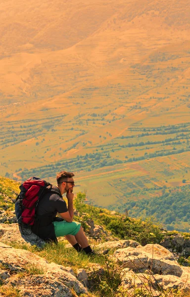 Wanderer ruht sich auf Felsen in den Bergen aus — Stockfoto