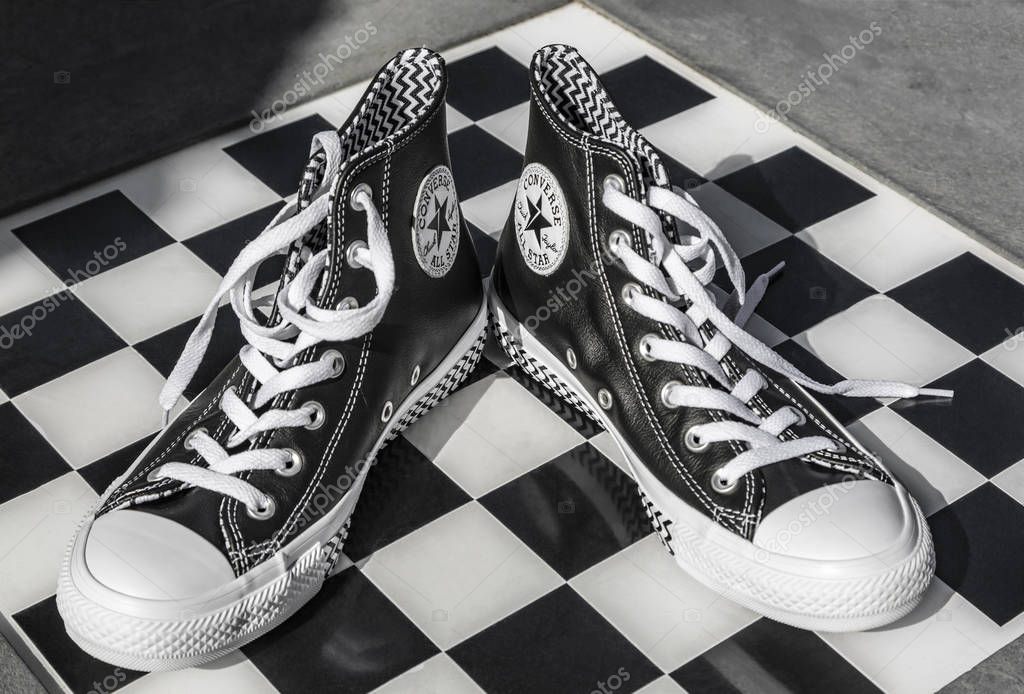 Chartres, France - Spetember 2, 2019: Image of a pair of All Star Converse sneakers on an urban black and white chess table
