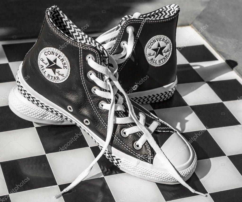 Chartres, France - Spetember 2, 2019: Image of a pair of All Star Converse sneakers on an urban black and white chess table