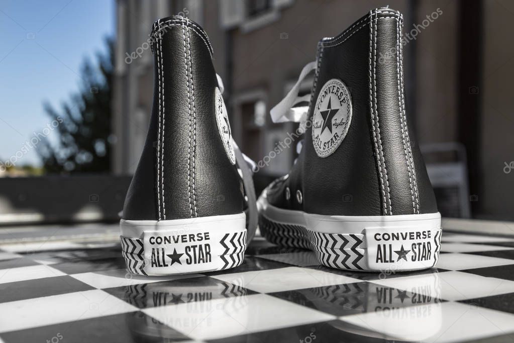 Chartres, France - Spetember 2, 2019: Image of a pair of All Star Converse sneakers on an urban black and white chess table