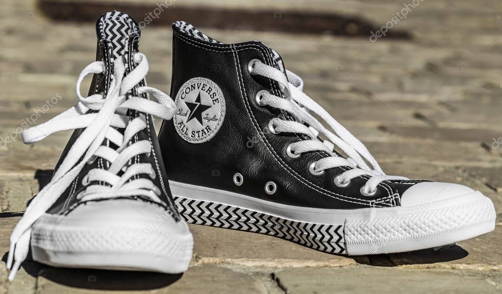 Chartres, France - Spetember 2, 2019: Image of a pair of All Star Converse sneakers on a cobblestone street.