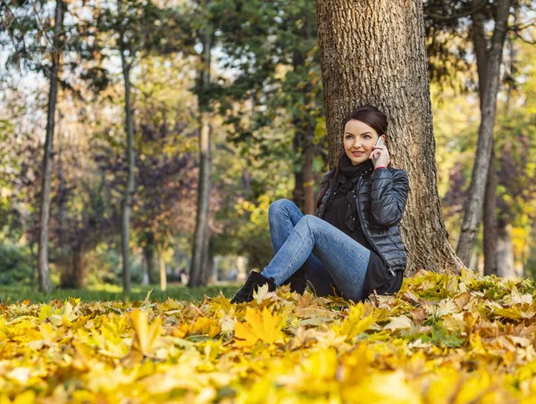 Γυναίκα σε ένα κινητό σε ένα δάσος το φθινόπωρο — Φωτογραφία Αρχείου