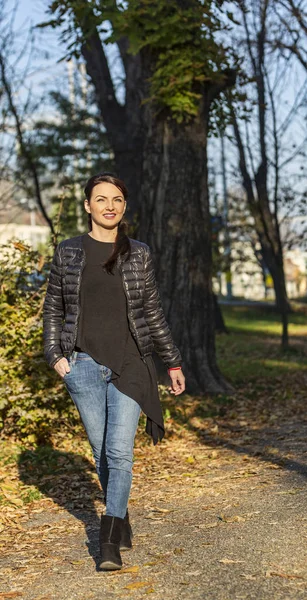 Une jeune femme marche dans un parc à l'automne — Photo