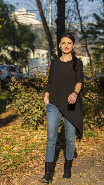 Молода жінка ходить в парку восени — стокове фото