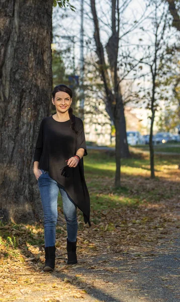 Mladá žena kráčí v parku na podzim — Stock fotografie