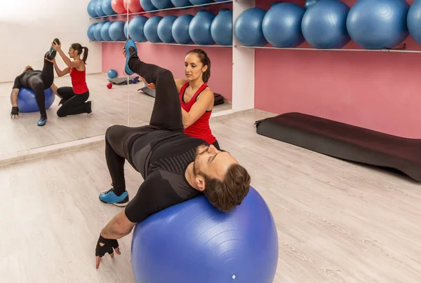 Koçunun Spor Salonunda Spor Topuyla Esneme Egzersizleri Yapmasına Yardım Eden — Stok fotoğraf