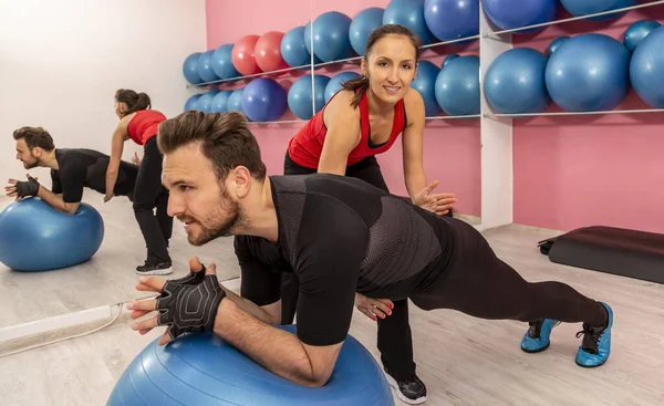 Junger Mann Mit Hilfe Seines Trainers Macht Dehnübungen Mit Fitnessball — Stockfoto