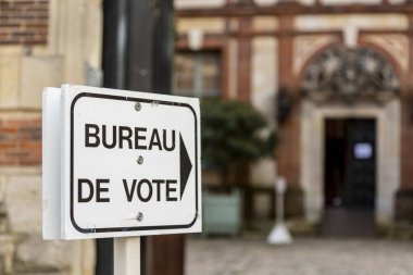Chartres, Fransa - 15 Mart 2020: 15 Mart 2020 'deki Fransa belediye seçimlerinin ilk turunda Fransa' da bir sandık merkezine giden bir rehber tabelanın resmi. Coronavirus tecridi sırasında Fransız halkına yerel seçimlerde oy kullanma çağrısı yapıldı