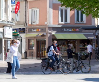 Chartres, Fransa - Avril 18, 2020: Korunmasız bir zanaatkar maskeli adam 2020 'deki koronavirüs krizi nedeniyle tecrit sırasında bisikletine biniyor.