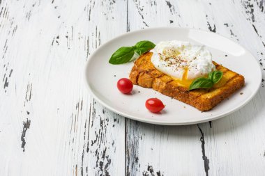 Ahşap masada bir parça ekmek üzerinde haşlanmış yumurta.