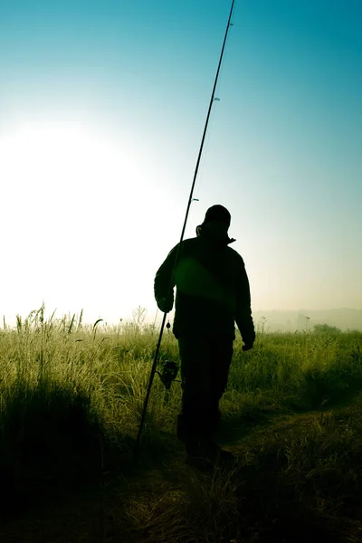 Pescador com uma vara de pesca em suas mãos — Fotografia de Stock