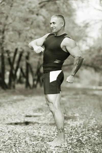 Deportista en la naturaleza haciendo ejercicios fotográficos en blanco y negro — Foto de Stock