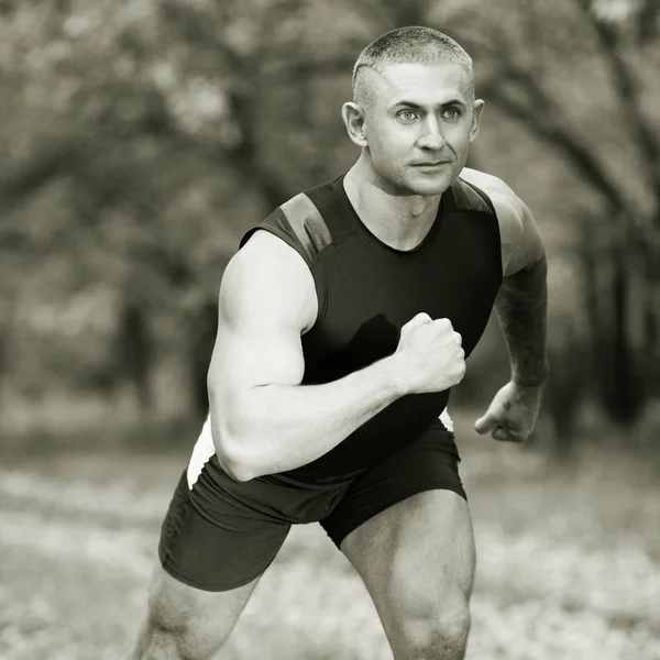 Deportista en la naturaleza haciendo ejercicios fotográficos en blanco y negro — Foto de Stock