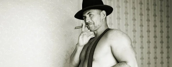 在一顶毡帽，在他手里，在黑色和白色叼着雪茄的肌肉牛仔 — 图库照片