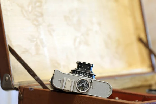 Old film camera against the background of a vintage suitcase — Stock Photo, Image