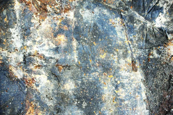 metal background of natural metal bent and beaten surface with old shabby paint of different colors, scratches rust and corrosion formed by time and weather