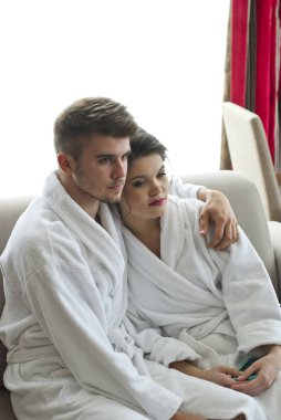 Bornoz koltukta oturan mutlu genç Çift