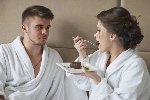 Красива усміхнена молода пара снідає в ліжку — стокове фото