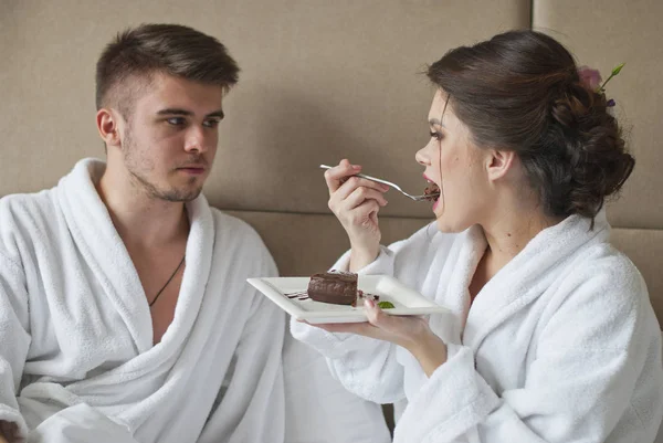 Hermosa joven pareja sonriente desayunando en la cama — Foto de Stock