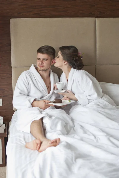 Hermosa joven pareja sonriente desayunando en la cama — Foto de Stock