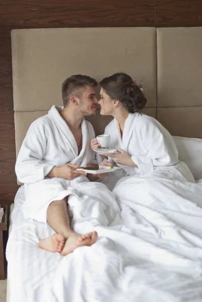 Frumos zâmbind tineri cuplu având micul dejun în pat — Fotografie, imagine de stoc