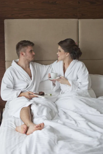 Frumos zâmbind tineri cuplu având micul dejun în pat — Fotografie, imagine de stoc