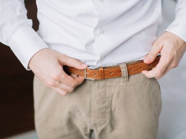 mutlu muhteşem yakışıklı damat hazırlanıyor sabah otel odasında giyinmiş. 