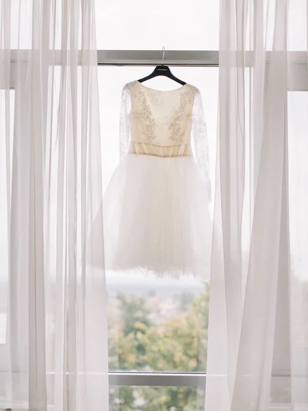Идеальное свадебное платье на вешалке в комнате невесты — стоковое фото