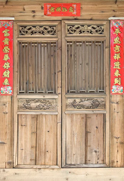 La antigua puerta de tallado en madera de estilo tradicional con pareados del festival de primavera durante el año nuevo chino . — Foto de Stock