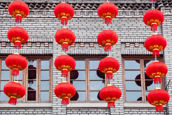 Group of red lanterns hanging on the black bricks wall in the Ch 로열티 프리 스톡 사진